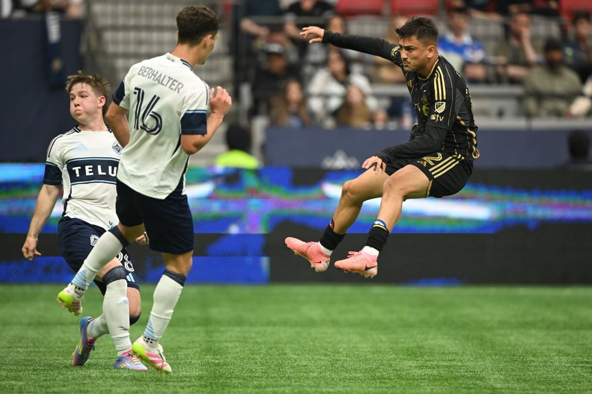 May 11, 2025; Vancouver, British Columbia, CAN;  Los Angeles FC midfielder Cengiz Under (22) shoots the ball against Vancouver Whitecaps FC midfielder Sebastian Berhalter (16) and defender Tate Johnson (28) during the second half at BC Place. Mandatory Credit: Anne-Marie Sorvin-Imagn Images