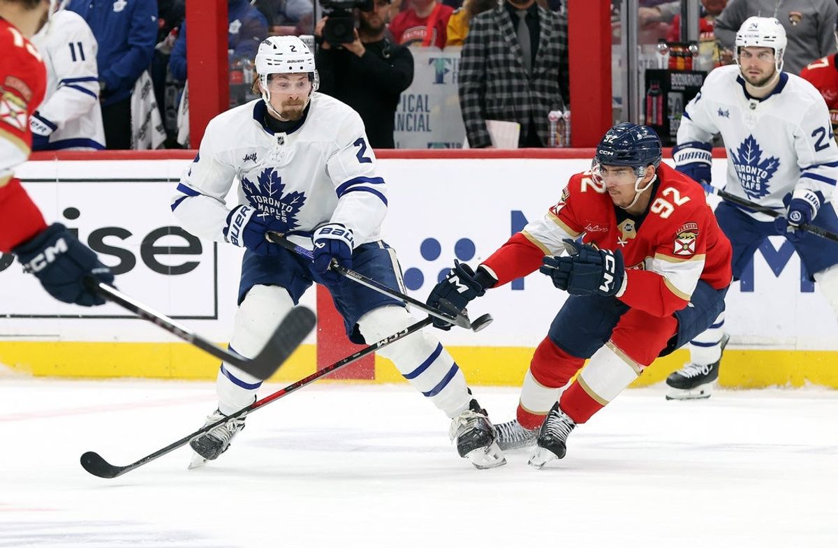 May 11, 2025; Sunrise, Florida, USA; Toronto Maple Leafs defenseman Simon Benoit (2) and Florida Panthers left wing Tomas Nosek (92) skate to control then puck during the third period in game four of the second round of the 2025 Stanley Cup Playoffs at Amerant Bank Arena. Mandatory Credit: Kim Klement Neitzel-Imagn Images