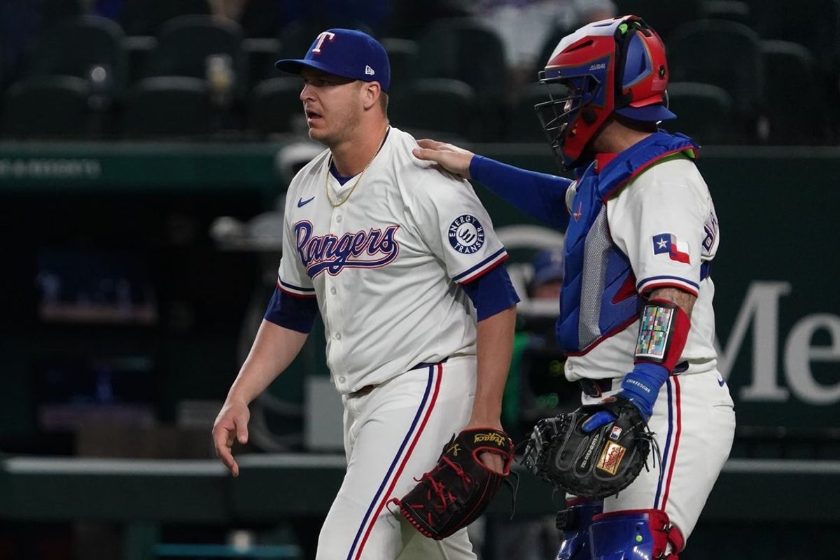 May 12, 2025; Arlington, Texas, USA; Texas Rangers catcher Tucker Barnhart (18) pats pitcher Jacob Webb (71) on the back after collecting the final out against the Colorado Rockies at Globe Life Field. Mandatory Credit: Raymond Carlin III-Imagn Images