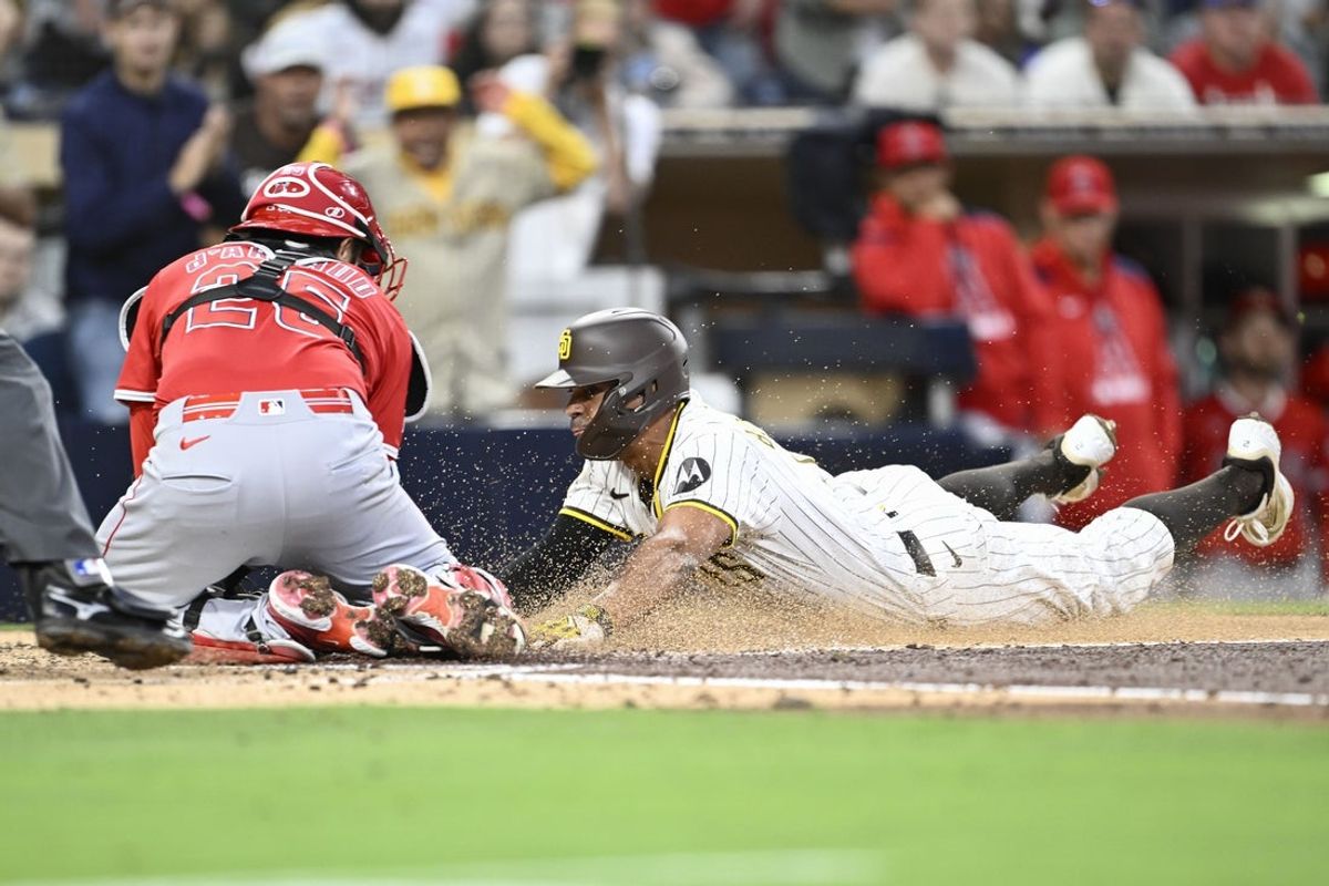 May 12, 2025; San Diego, California, USA; San Diego Padres shortstop Xander Bogaerts (2) is tagged out at the plate by Los Angeles Angels catcher Travis d'Arnaud (25) during the third inning at Petco Park. Mandatory Credit: Denis Poroy-Imagn Images