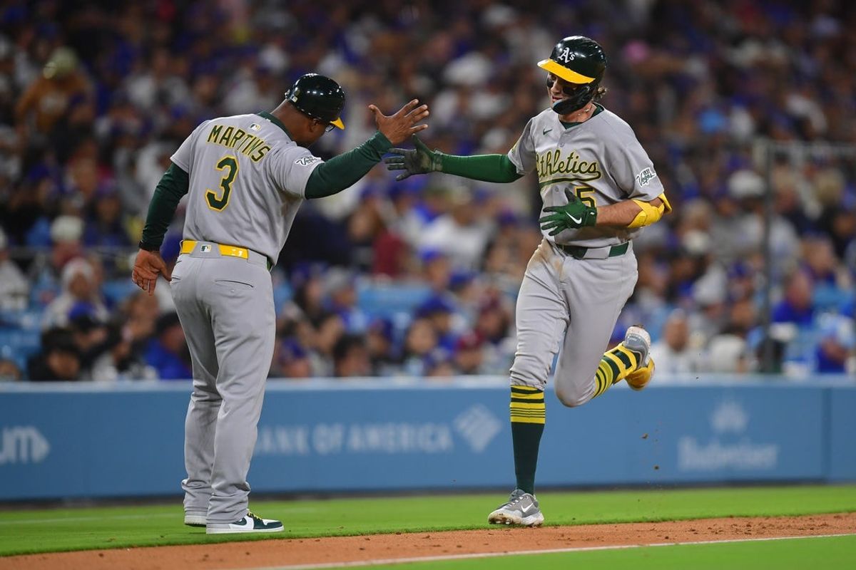 May 13, 2025; Los Angeles, California, USA; Athletics shortstop Jacob Wilson (5) is greeted by third base coach Eric Martins (3) after hitting a two run home run against the Los Angeles Dodgers during the fifth inning at Dodger Stadium. Mandatory Credit: Gary A. Vasquez-Imagn Images
