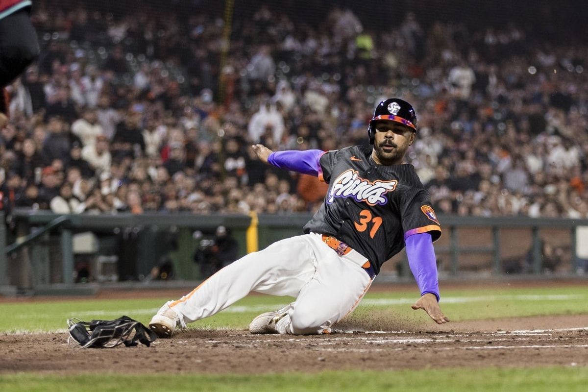 May 13, 2025; San Francisco, California, USA;  San Francisco Giants first baseman LaMonte Wade Jr. (31) slides home to score on a wild pitch by Arizona Diamondbacks relief pitcher Juan Morillo (67) (not pictured) during the fifth inning at Oracle Park. Mandatory Credit: John Hefti-Imagn Images