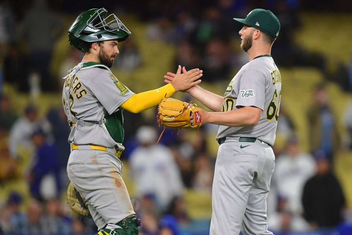 May 13, 2025; Los Angeles, California, USA; Athletics catcher Shea Langeliers (23) and pitcher Justin Sterner (60) celebrate the victory against the Los Angeles Dodgers at Dodger Stadium. Mandatory Credit: Gary A. Vasquez-Imagn Images