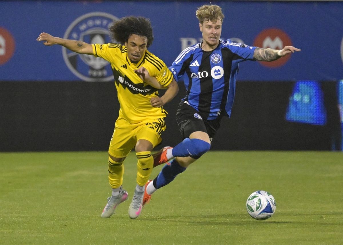 May 14, 2025; Montreal, Province of Quebec, CAN; Columbus Crew midfielder Aziel Jackson (13) and CF Montreal defender Dawid Bugaj (27) play the ball during the first half at Saputo Stadium. Mandatory Credit: Eric Bolte-Imagn Images