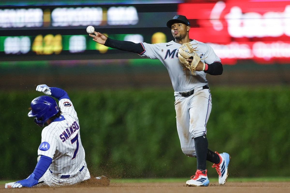 May 14, 2025; Chicago, Illinois, USA; Miami Marlins shortstop Xavier Edwards (9) throws out Chicago Cubs shortstop Dansby Swanson (7) at second base during the eight inning at Wrigley Field. Mandatory Credit: Kamil Krzaczynski-Imagn Images