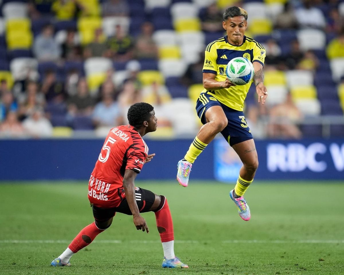 Nashville SC midfielder Andy Najar (31) leaps for the ball next to New York Red Bulls defender Omar Valencia (5) during the first half at Geodis Park in Nashville, Tenn., Wednesday, May 14, 2025.