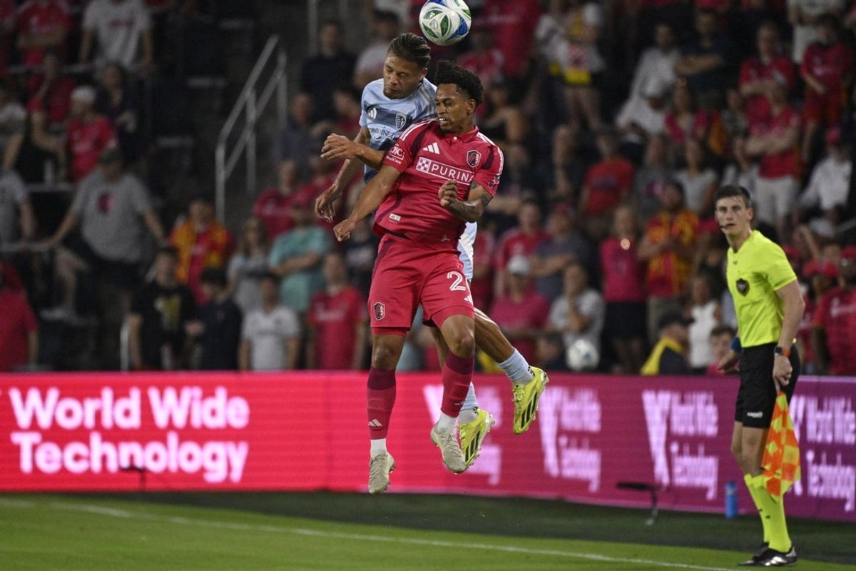 May 14, 2025; St. Louis, Missouri, USA; Sporting Kansas City defender Zorhan Bassong (22) and St. Louis CITY SC midfielder Akil Watts (20) go up for a header in the first half at Energizer Park. Mandatory Credit: Joe Puetz-Imagn Images