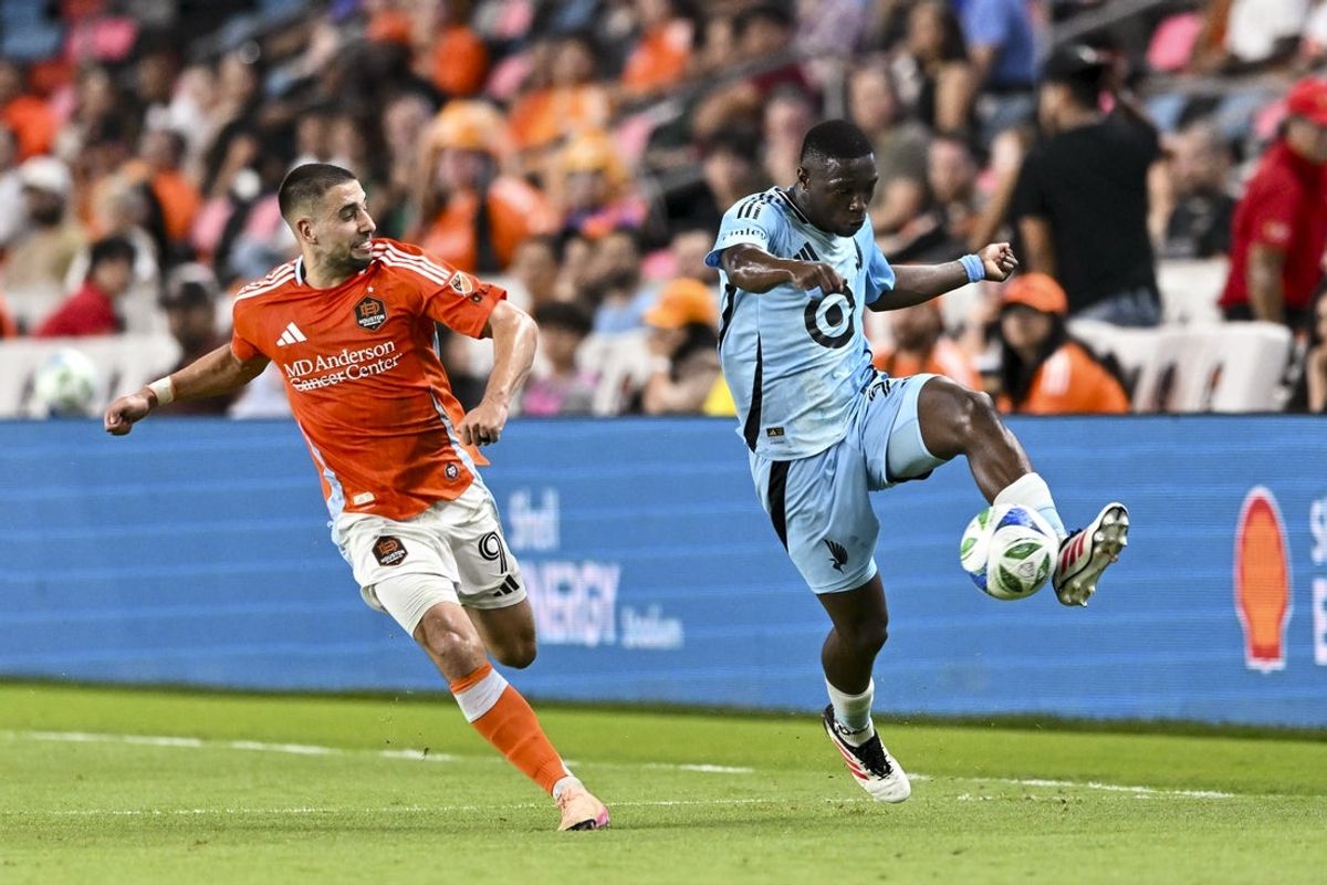 May 14, 2025; Houston, Texas, USA; Minnesota United FC forward Bongokuhle Hlongwane (21) kicks the ball during the second half as Houston Dynamo FC midfielder Ondrej Lingr (9) defends at Shell Energy Stadium. Mandatory Credit: Maria Lysaker-Imagn Images