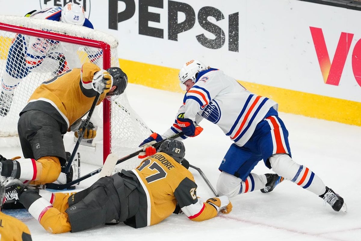 May 14, 2025; Las Vegas, Nevada, USA; Edmonton Oilers right wing Kasperi Kapanen (42) digs the puck out from under the skate of Vegas Golden Knights goaltender Adin Hill (33) to score a game-winning goal in overtime to give the Oilers a 1-0 victory in the game and a 4-1 series win during game five of the second round of the 2025 Stanley Cup Playoffs at T-Mobile Arena. Mandatory Credit: Stephen R. Sylvanie-Imagn Images