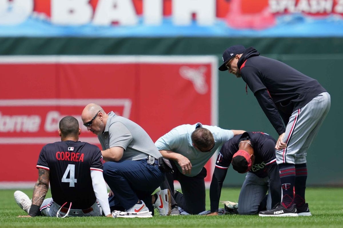 May 15, 2025; Baltimore, Maryland, USA; Minnesota Twins outfielder Byron Buxton (25) and shortstop Carlos Correa (4) remain on the ground following a collision while chasing the ball during the third inning against the Baltimore Orioles at Oriole Park at Camden Yards. Mandatory Credit: Mitch Stringer-Imagn Images