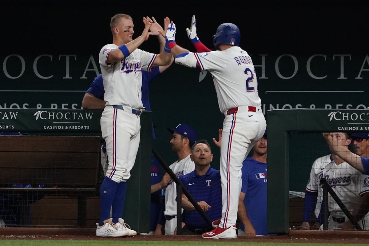 May 15, 2025; Arlington, Texas, USA; Texas Rangers first baseman Jake Burger (21) is greeted by third baseman Josh Jung (6) at the dugout steeps after hitting a solo home run during the sixth inning against the Houston Astros at Globe Life Field. Mandatory Credit: Raymond Carlin III-Imagn Images