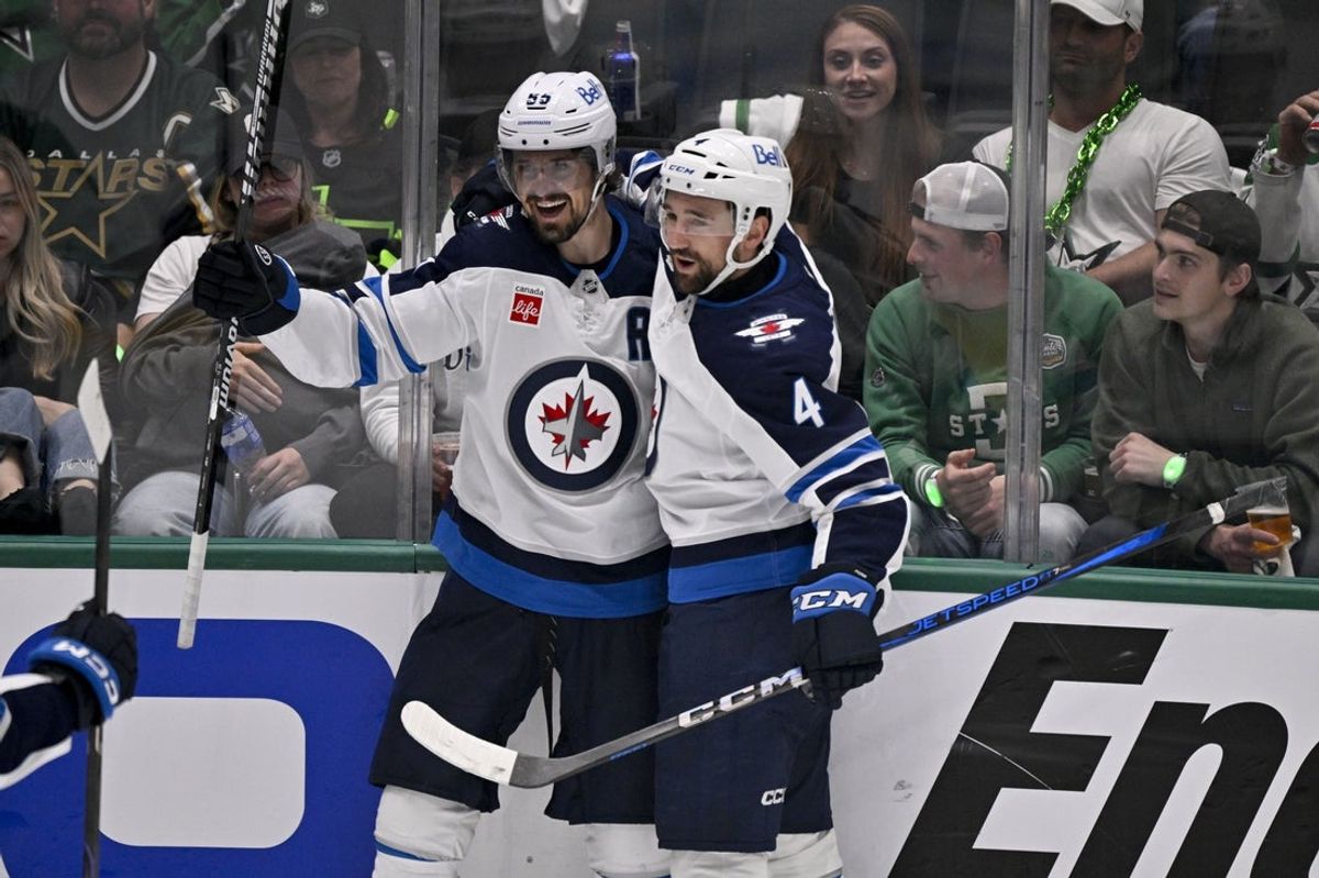 May 17, 2025; Dallas, Texas, USA; Winnipeg Jets center Mark Scheifele (55) and defenseman Neal Pionk (4) celebrates a goal scored by Scheifele against the Dallas Stars during the second period in game six of the second round of the 2025 Stanley Cup Playoffs at American Airlines Center. Mandatory Credit: Jerome Miron-Imagn Images