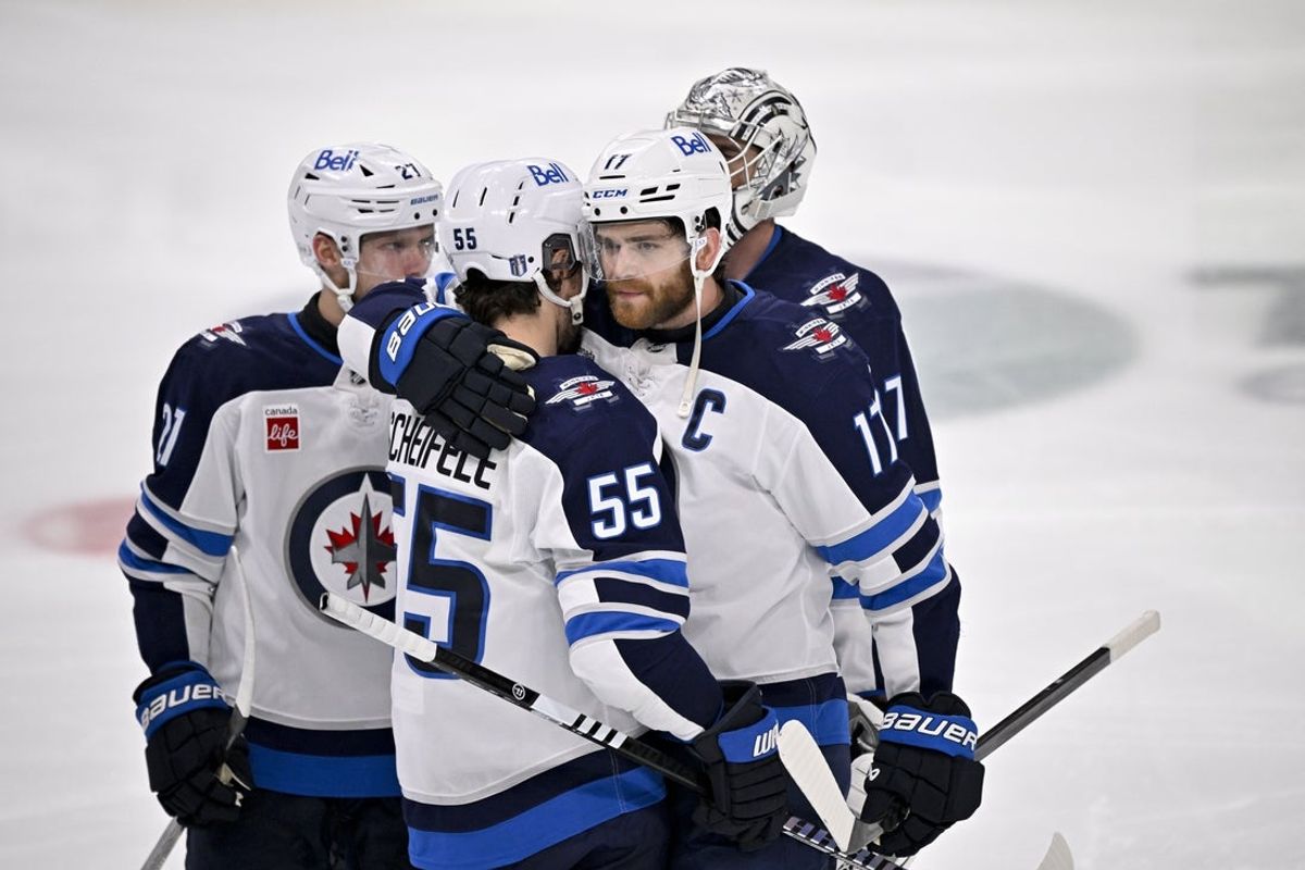 May 17, 2025; Dallas, Texas, USA; Winnipeg Jets center Adam Lowry (17) hugs center Mark Scheifele (55) after the Jets lose to the Dallas Stars during the overtime period in game six of the second round of the 2025 Stanley Cup Playoffs at American Airlines Center. Mandatory Credit: Jerome Miron-Imagn Images