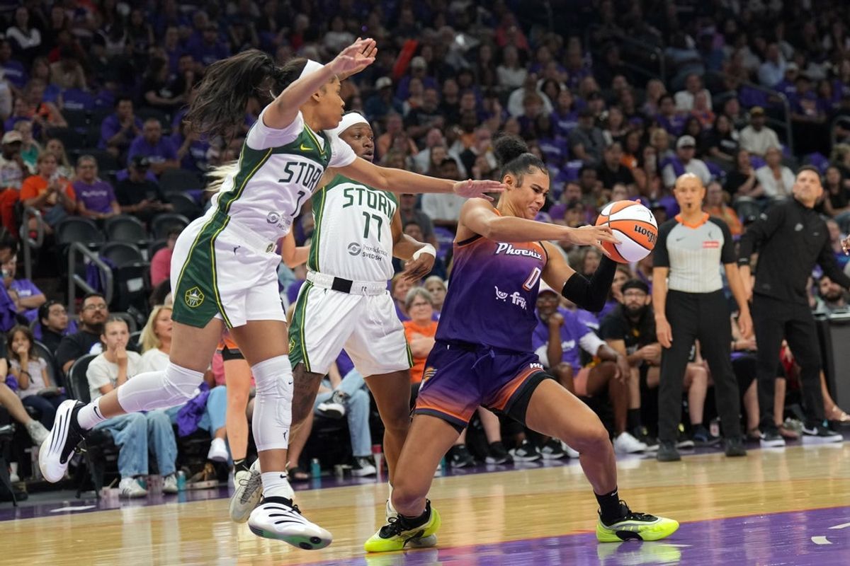 May 17, 2025; Phoenix, Arizona, USA; Phoenix Mercury forward Satou Sabally (0) protects the ball from Seattle Storm guard Zia Cooke (7) and Seattle Storm guard Erica Wheeler (17) during the second half at Footprint Center. Mandatory Credit: Joe Camporeale-Imagn Images