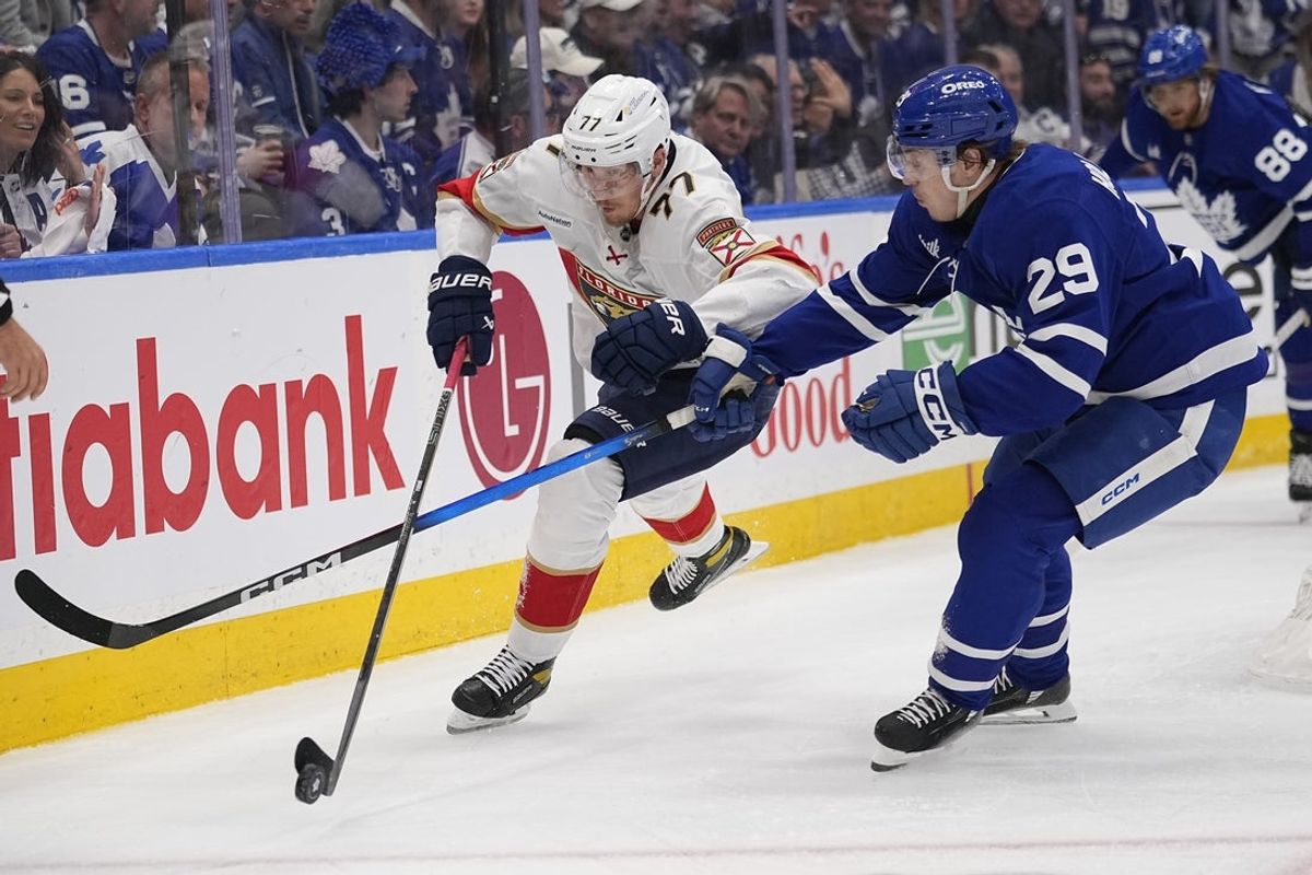 May 18, 2025; Toronto, Ontario, CAN; Florida Panthers defenseman Niko Mikkola (77) tries to control the puck against Toronto Maple Leafs forward Pontus Holmberg (29) during the first period of game seven of the second round of the 2025 Stanley Cup Playoffs at Scotiabank Arena. Mandatory Credit: John E. Sokolowski-Imagn Images
