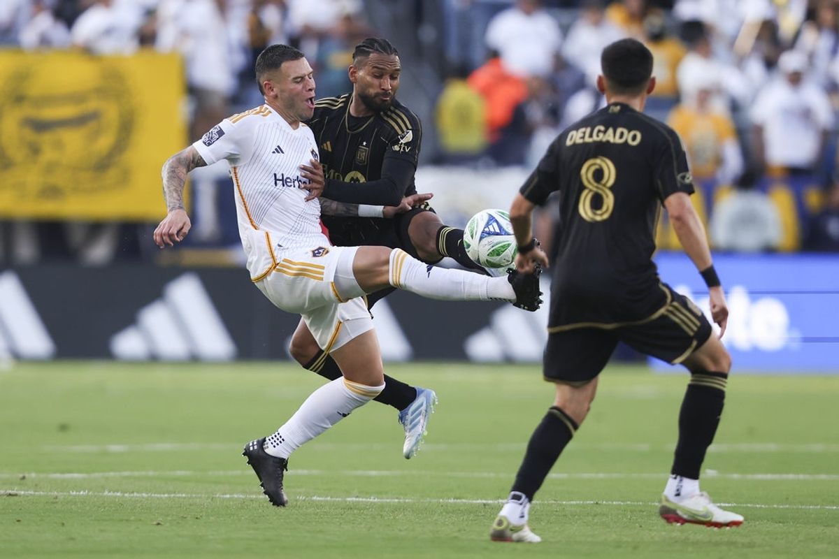 May 18, 2025; Carson, California, USA; Los Angeles Galaxy forward Christian Ramirez (17) and Los Angeles FC defender Eddie Segura (4) battle for the ball during the first half of a soccer game at Dignity Health Sports Park. Mandatory Credit: Jessica Alcheh-Imagn Images