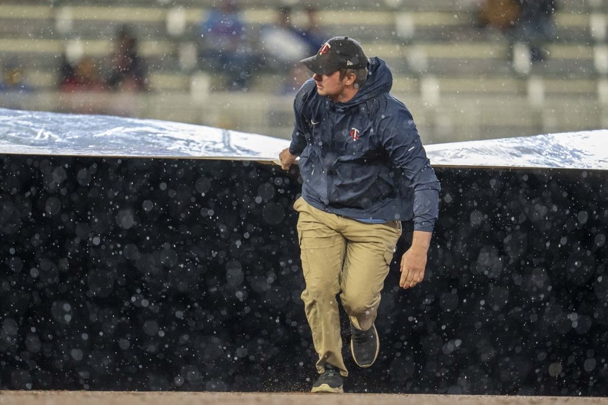 May 19, 2025; Minneapolis, Minnesota, USA; Minnesota Twins grounds crew roll out the on field tarp during the second inning in a game between the Cleveland Guardians and Minnesota Twins at Target Field. Mandatory Credit: Jesse Johnson-Imagn Images