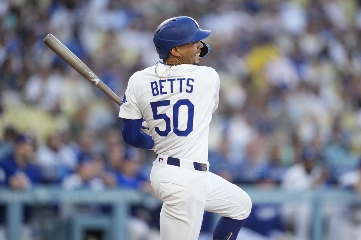 May 20, 2025; Los Angeles, California, USA; Los Angeles Dodgers shortstop Mookie Betts (50) singles on a line drive in the first inning against the Arizona Diamondbacks  at Dodger Stadium. Mandatory Credit: Kirby Lee-Imagn Images