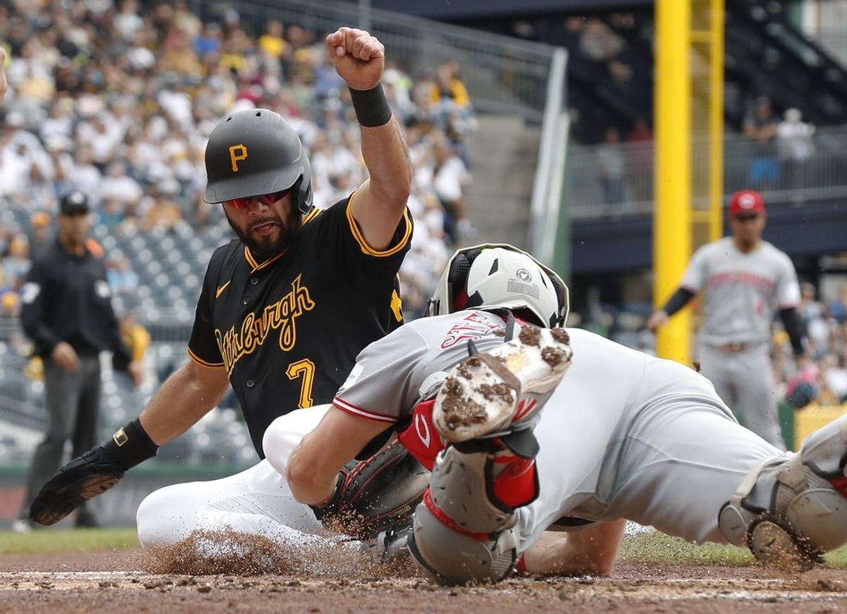 May 21, 2025; Pittsburgh, Pennsylvania, USA;  Cincinnati Reds catcher Tyler Stephenson (right) tags Pittsburgh Pirates shortstop Isiah Kiner-Falefa (7) out at home plate attempting to score during the first inning at PNC Park. Mandatory Credit: Charles LeClaire-Imagn Images