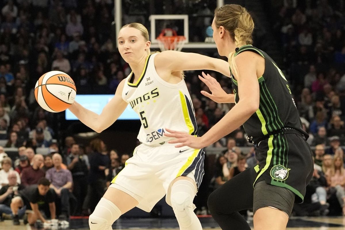 May 21, 2025; Minneapolis, Minnesota, USA; Dallas Wings guard Paige Bueckers (5) passes against Minnesota Lynx forward Alanna Smith (8) in the second quarter at Target Center. Mandatory Credit: Bruce Kluckhohn-Imagn Images