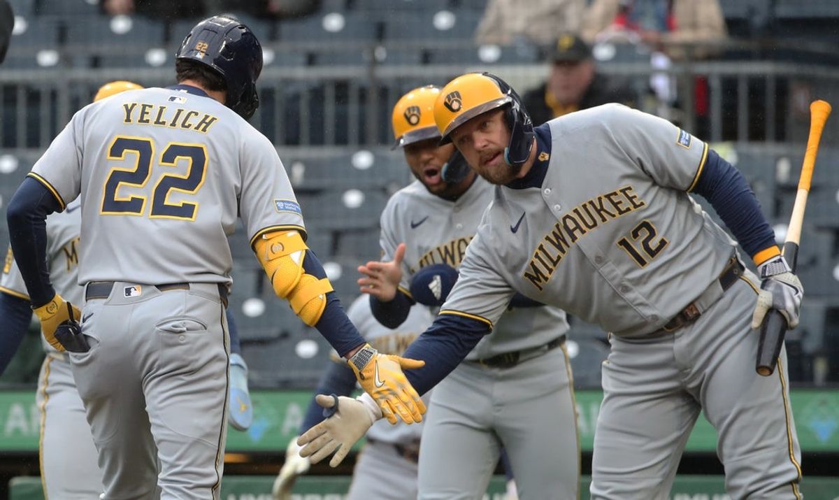 May 22, 2025; Pittsburgh, Pennsylvania, USA;  Milwaukee Brewers first baseman Rhys Hoskins (12) congratulates designated hitter Christian Yelich (22) crossing home plate on a on a three run home run against the Pittsburgh Pirates during the first inning at PNC Park. Mandatory Credit: Charles LeClaire-Imagn Images