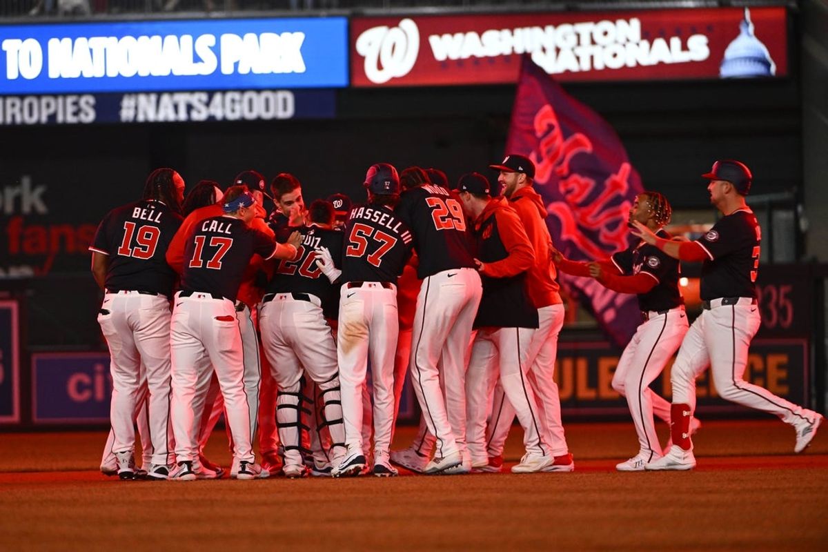 May 22, 2025; Washington, District of Columbia, USA; Washington Nationals third base Amed Rosario (13) is mobbed by teammates after hitting a walk off single against the Atlanta Braves during the tenth inning at Nationals Park. Mandatory Credit: Brad Mills-Imagn Images