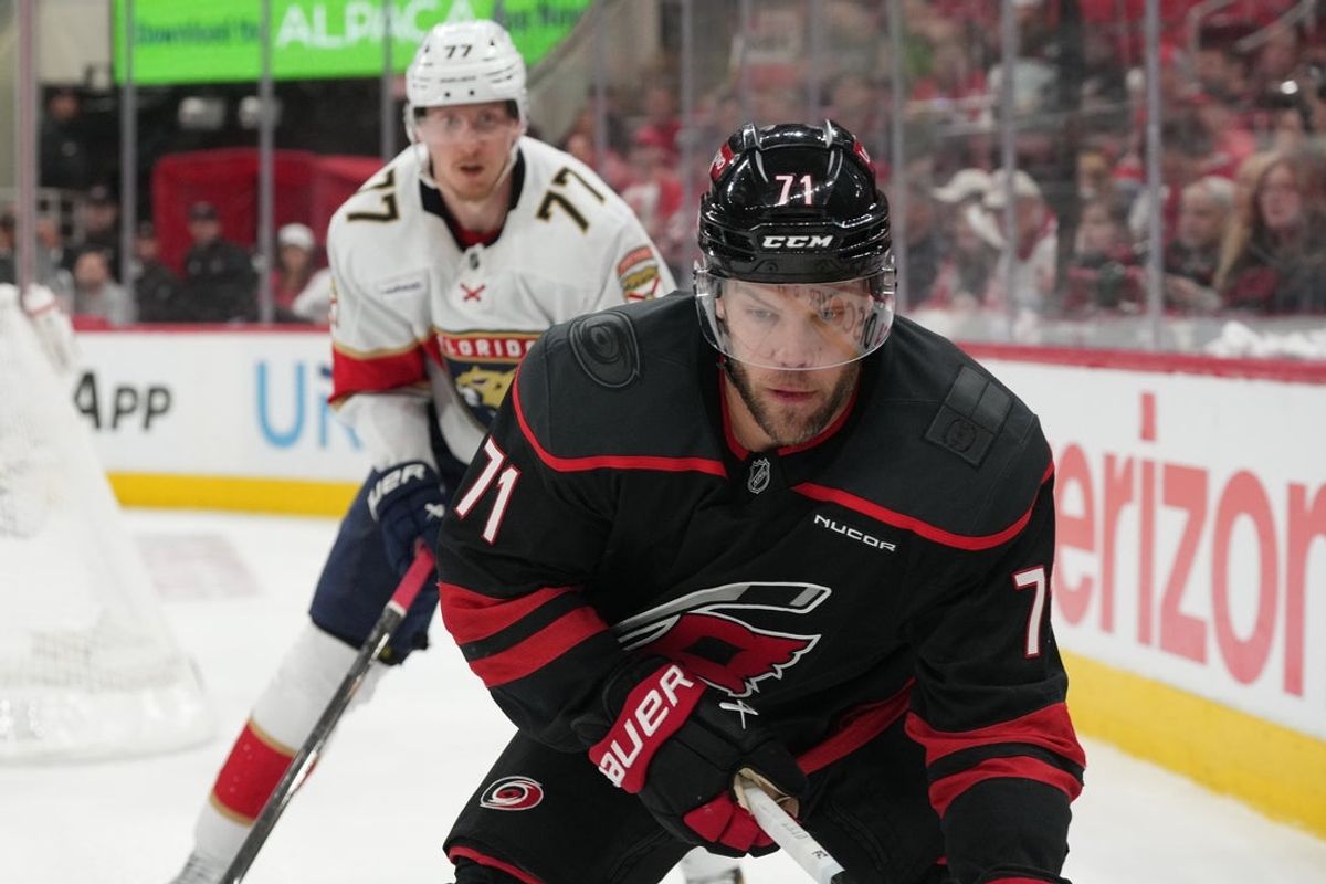 May 22, 2025; Raleigh, North Carolina, USA; Carolina Hurricanes forward Taylor Hall (71) goes into the corner against Florida Panthers defenseman Niko Mikkola (77) during the third period in game two of the Eastern Conference Final of the 2025 Stanley Cup Playoffs at Lenovo Center. Mandatory Credit: James Guillory-Imagn Images