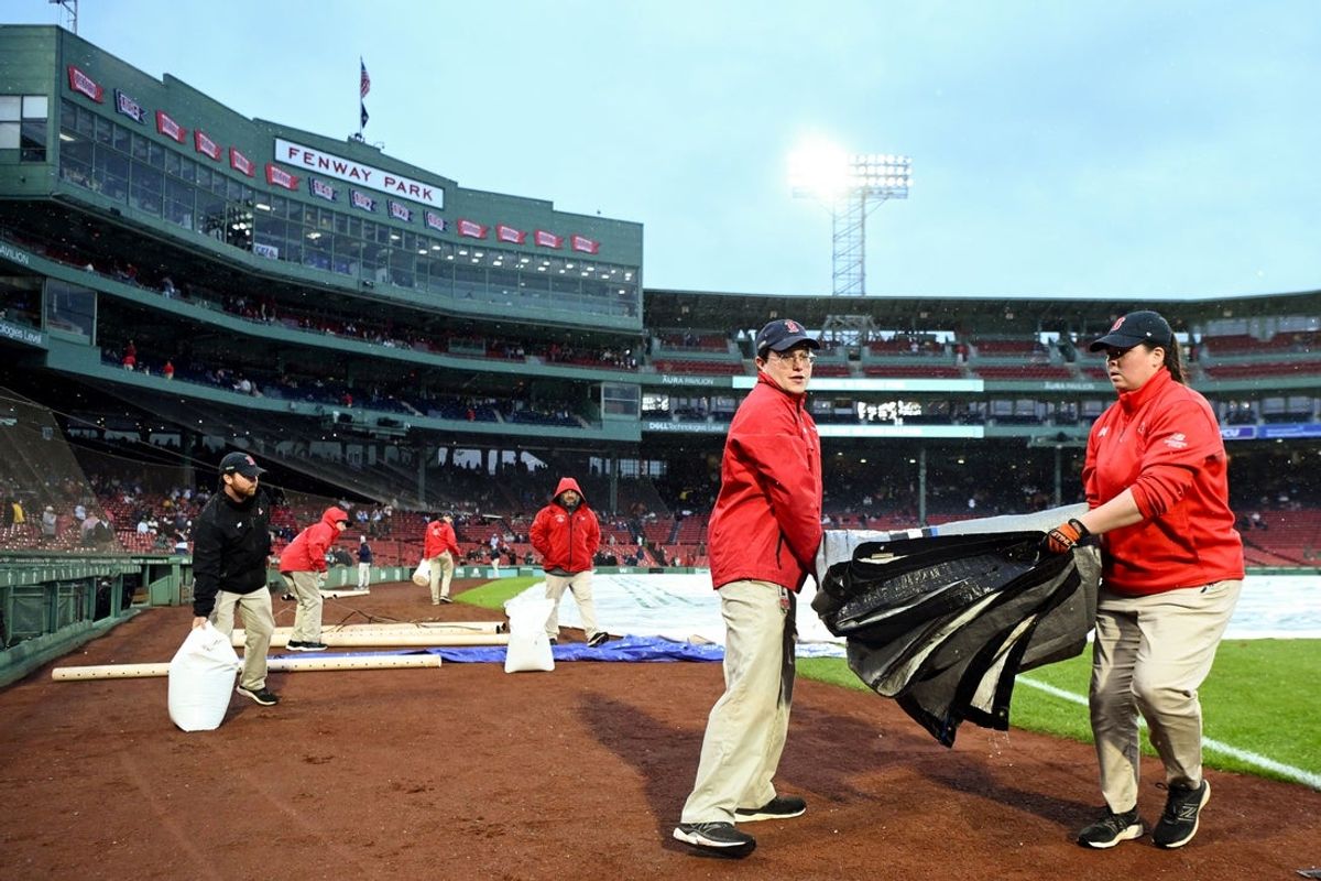 May 23, 2025; Boston, Massachusetts, USA; Grounds crew members cover the infield after a game between the Baltimore Orioles and Boston Red Sox was postponed at Fenway Park. Mandatory Credit: Brian Fluharty-Imagn Images