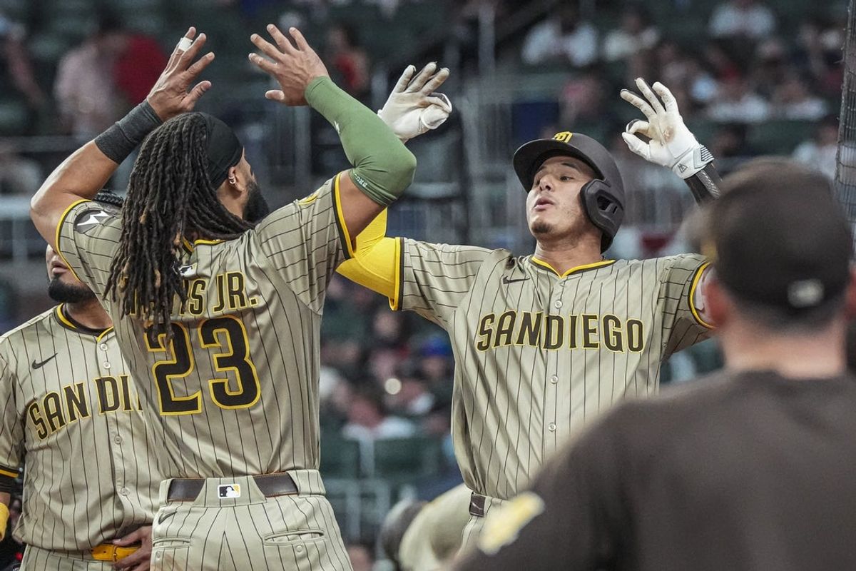 May 23, 2025; Cumberland, Georgia, USA; San Diego Padres third baseman Manny Machado (13) reacts with right fielder Fernando Tatis Jr. (23) after hitting a go ahead home run against the Atlanta Braves during the ninth inning at Truist Park. Mandatory Credit: Dale Zanine-Imagn Images
