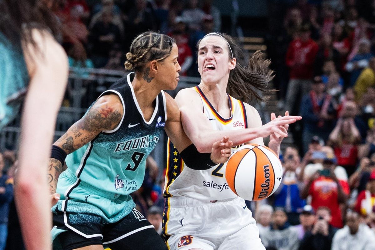 May 24, 2025; Indianapolis, Indiana, USA; Indiana Fever guard Caitlin Clark (22) dribbles  the ball while New York Liberty guard Natasha Cloud (9) defends in the second half at Gainbridge Fieldhouse. Mandatory Credit: Trevor Ruszkowski-Imagn Images