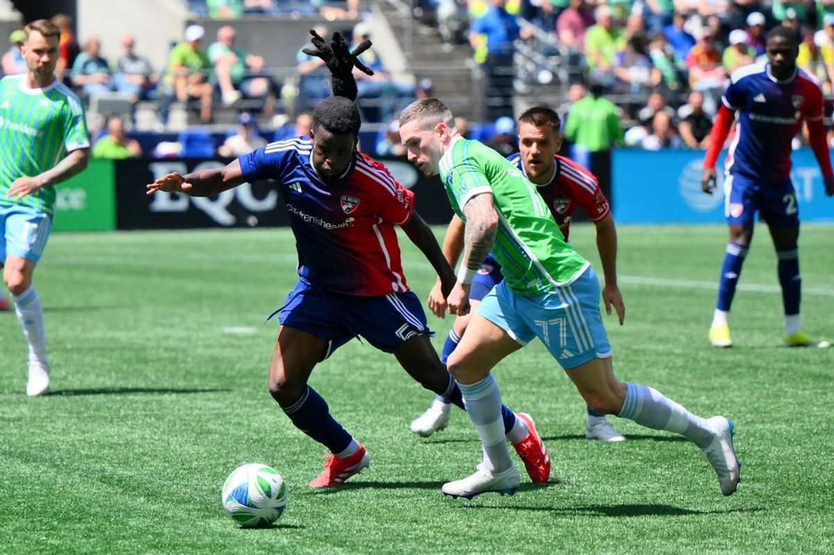 May 24, 2025; Seattle, Washington, USA; Seattle Sounders midfielder Ryan Kent (77) chases the ball against FC Dallas defender Lalas Abubakar (5) during the first half at Lumen Field. Mandatory Credit: Steven Bisig-Imagn Images