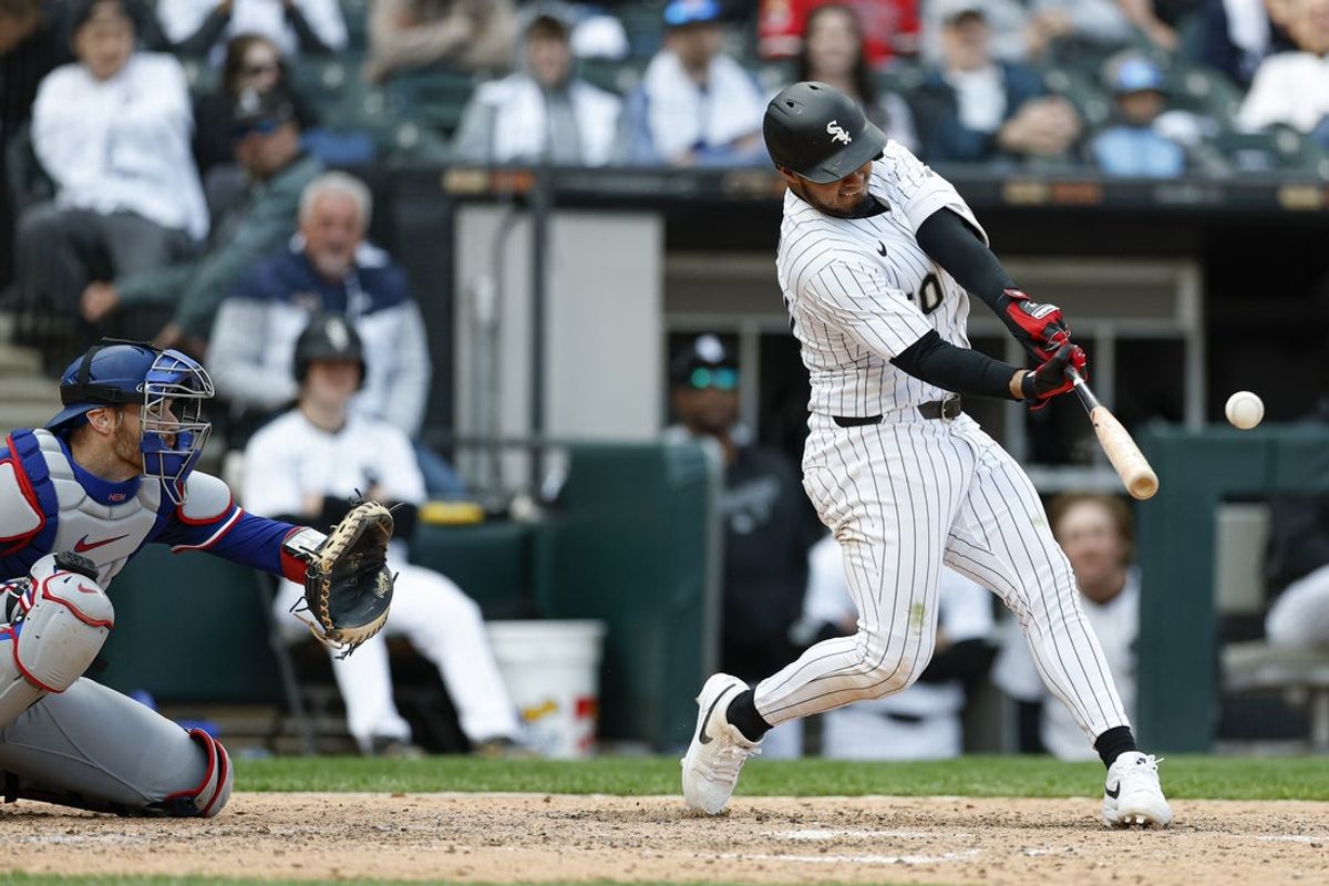 May 24, 2025; Chicago, Illinois, USA; Chicago White Sox second baseman Lenyn Sosa (50) hits a three-run double against the Texas Rangers during the sixth inning at Rate Field. Mandatory Credit: Kamil Krzaczynski-Imagn Images