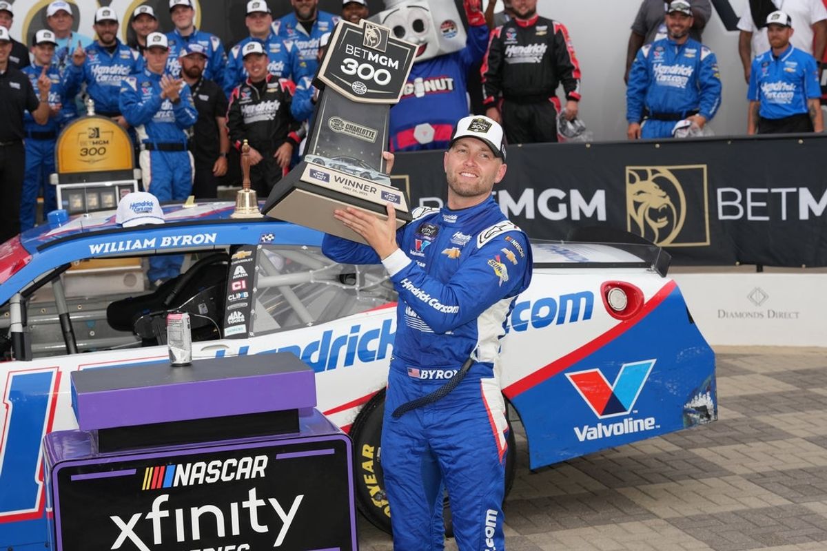 May 24, 2025; Concord, North Carolina, USA;  William Byron (17) hoists the trophy after his win during the Bet MGM 300 at Charlotte Motor Speedway. Mandatory Credit: Jim Dedmon-Imagn Images