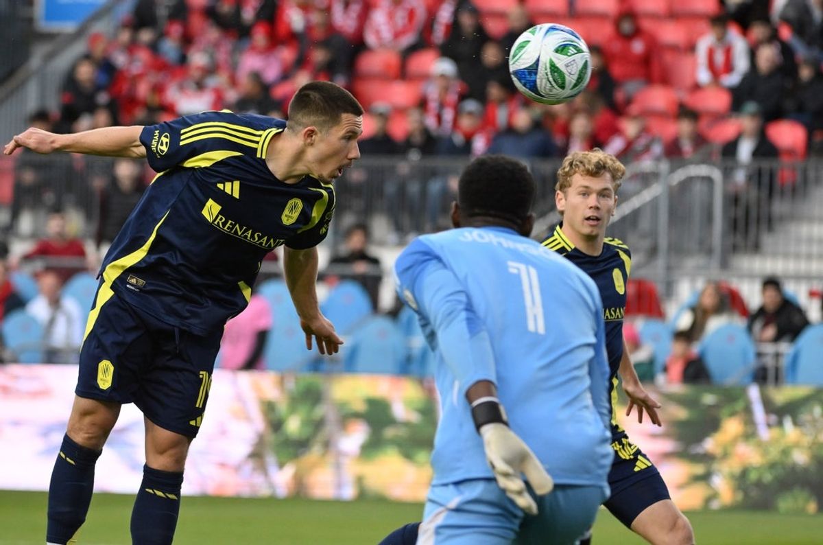 May 24, 2025; Toronto, Ontario, CAN;  Nashville SC forward Sam Surridge (9) tries to head the ball past Toronto FC goalkeeper Sean Johnson (1) as midfielder Jacob Shaffelburg (14) looks on in the first half at BMO Field. Mandatory Credit: Dan Hamilton-Imagn Images