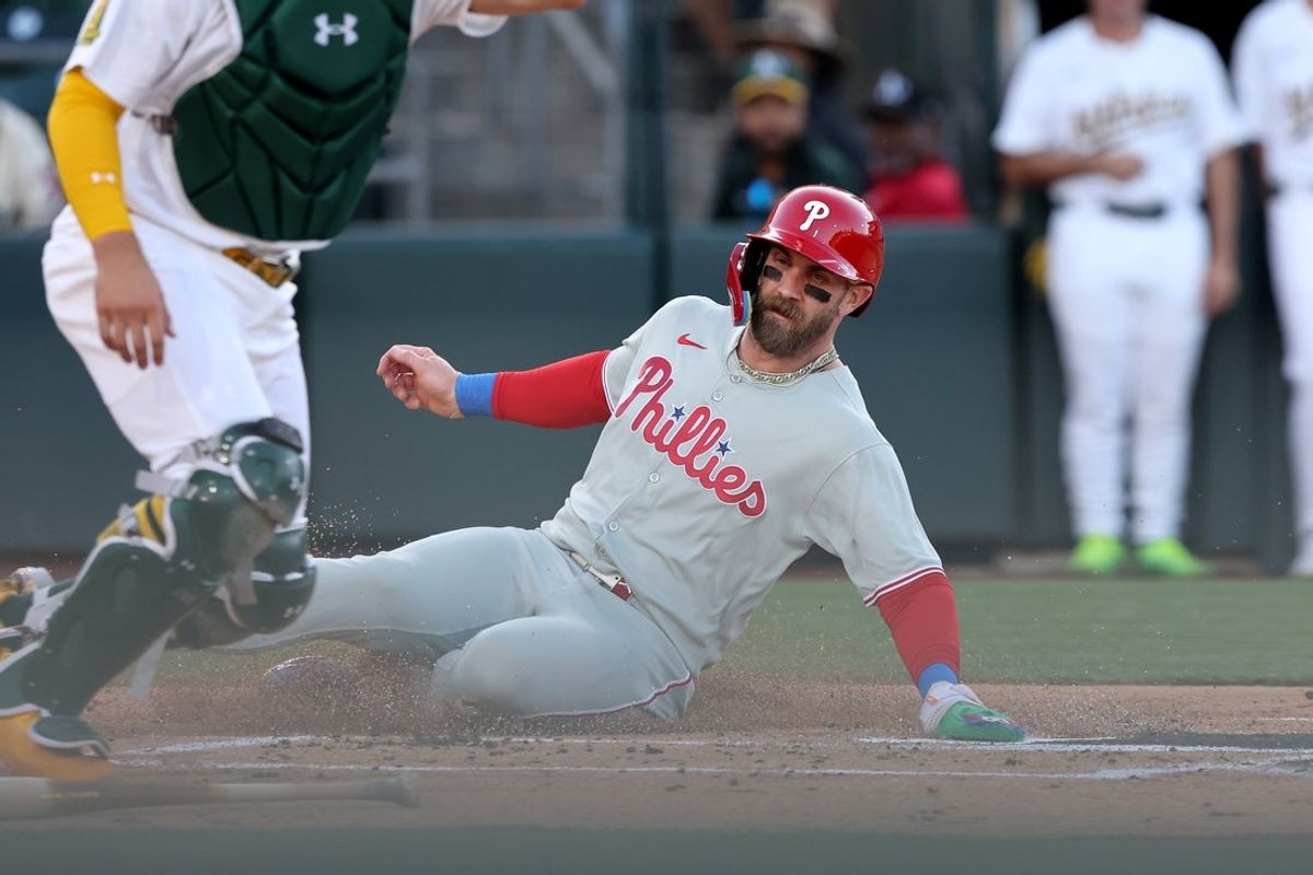 May 24, 2025; West Sacramento, California, USA; Philadelphia Phillies first baseman Bryce Harper (3) slides into home on a double hit by Nick Castellanos (8) against the Athletics during the first inning at Sutter Health Park. Mandatory Credit: Dennis Lee-Imagn Images