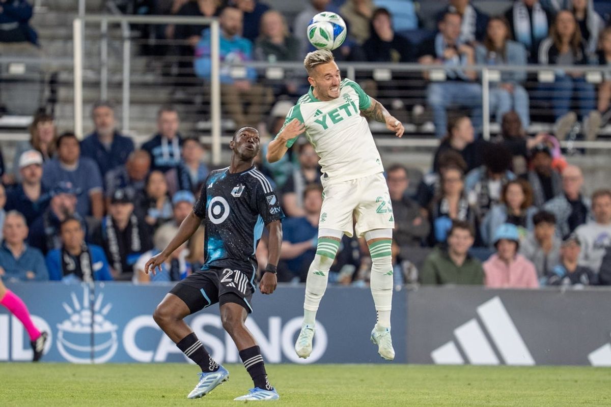 May 24, 2025; Saint Paul, Minnesota, USA; Austin FC defender Zan Kolmanic (23) heads a pass away form Minnesota United forward Bongokuhle Hlongwane (21) in the second half at Allianz Field. Mandatory Credit: Matt Blewett-Imagn Images