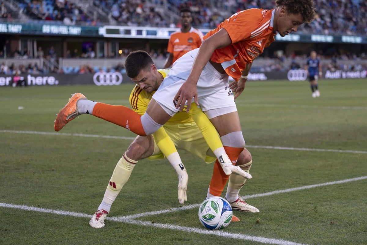 May 24, 2025; San Jose, California, USA;  Houston Dynamo goalkeeper Jonathan Bond (31) reaches for the ball from Houston Dynamo defender Obafemi Awodesu (24) during the first half against the San Jose Earthquakes at PayPal Park. Mandatory Credit: Stan Szeto-Imagn Images