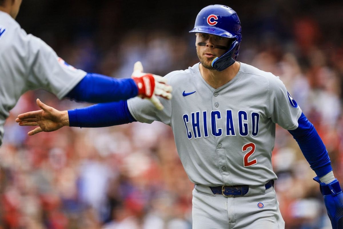 May 25, 2025; Cincinnati, Ohio, USA; Chicago Cubs second baseman Nico Hoerner (2) high fives a teammate after scoring on a single hit by first baseman Michael Busch (not pictured) in the seventh inning against the Cincinnati Reds at Great American Ball Park. Mandatory Credit: Katie Stratman-Imagn Images