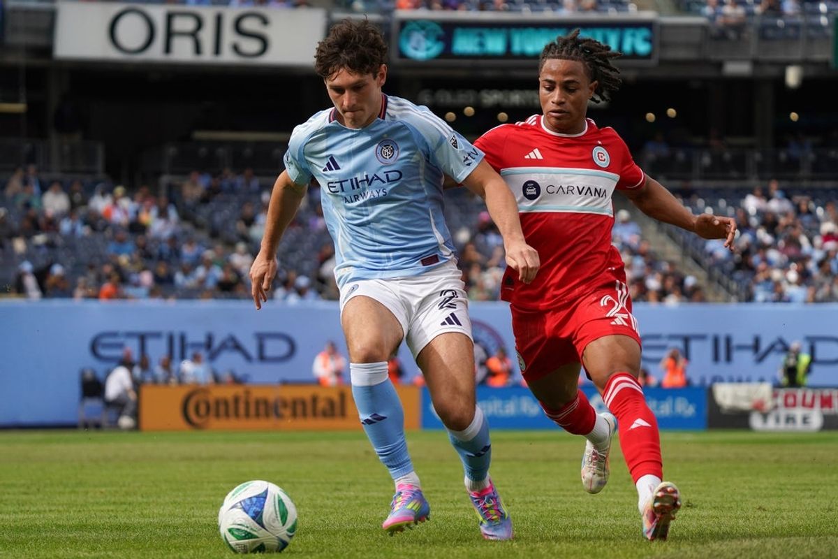 May 25, 2025; New York, New York, USA; New York City FC defender Nico Cavallo (2) and Chicago Fire FC defender Arnaud Souquet (2) race to a ball during the second half at Yankee Stadium. Mandatory Credit: Lucas Boland-Imagn Images