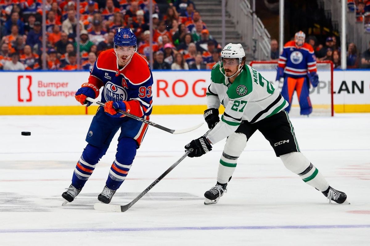 May 25, 2025; Edmonton, Alberta, CAN; Edmonton Oilers center Ryan Nugent-Hopkins (93) and Dallas Stars left wing Mason Marchment (27) chase the puck during the third period in game three of the Western Conference Final of the 2025 Stanley Cup Playoffs at Rogers Place. Mandatory Credit: Perry Nelson-Imagn Images
