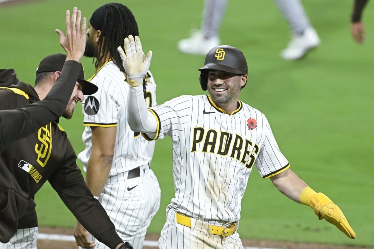 May 26, 2025; San Diego, California, USA; San Diego Padres center fielder Tyler Wade (14) is congratulated after scoring on a wild pitch during the 11th inning against the Miami Marlins at Petco Park. Mandatory Credit: Denis Poroy-Imagn Images