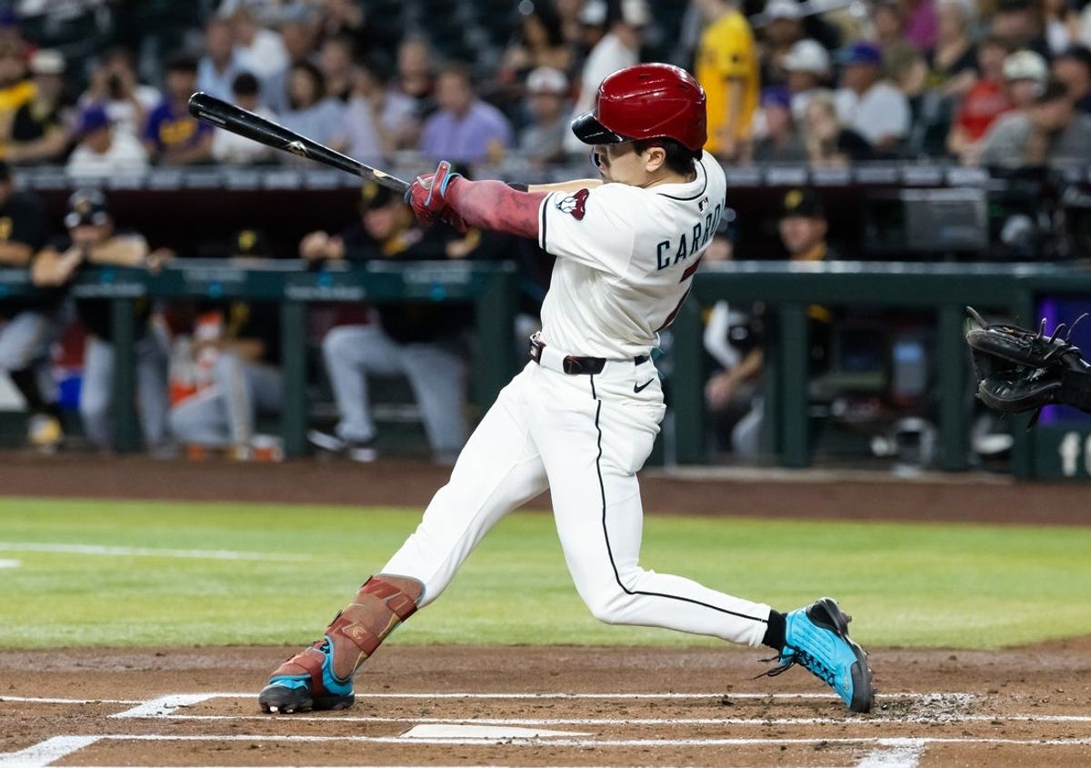 May 27, 2025; Phoenix, Arizona, USA; Arizona Diamondbacks outfielder Corbin Carroll hits a solo home run in the first inning against the Pittsburgh Pirates at Chase Field. Mandatory Credit: Mark J. Rebilas-Imagn Images