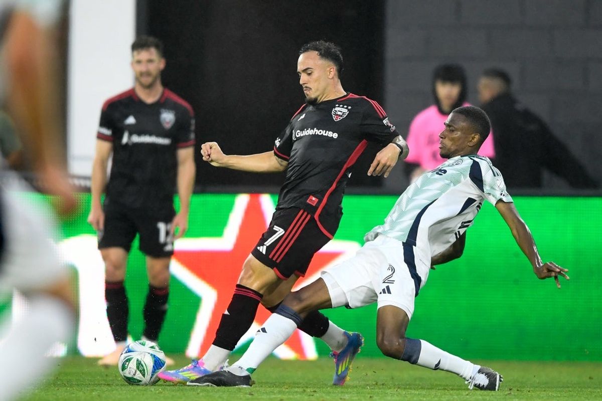 May 28, 2025; Washington, District of Columbia, USA; New England Revolution defender Mamadou Fofana (2) challenges D.C. United forward Joao Peglow (7) for the ball during the first half of the game at Audi Field. Mandatory Credit: Hannah Foslien-Imagn Images