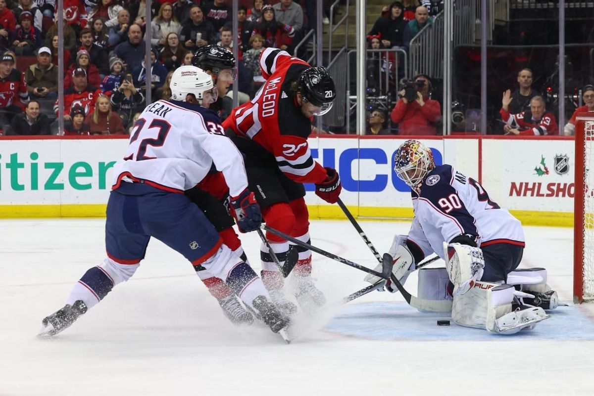 Dec 27, 2023; Newark, New Jersey, USA; Columbus Blue Jackets goaltender Elvis Merzlikins (90) makes a save on New Jersey Devils center Michael McLeod (20) during the second period at Prudential Center.