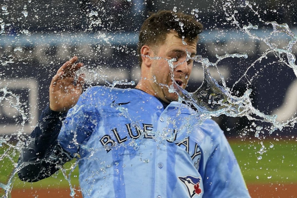 May 29, 2025; Toronto, Ontario, CAN; Toronto Blue Jays third baseman Ernie Clement (22) gets doused with water after win over the Athletics at Rogers Centre. Mandatory Credit: John E. Sokolowski-Imagn Images