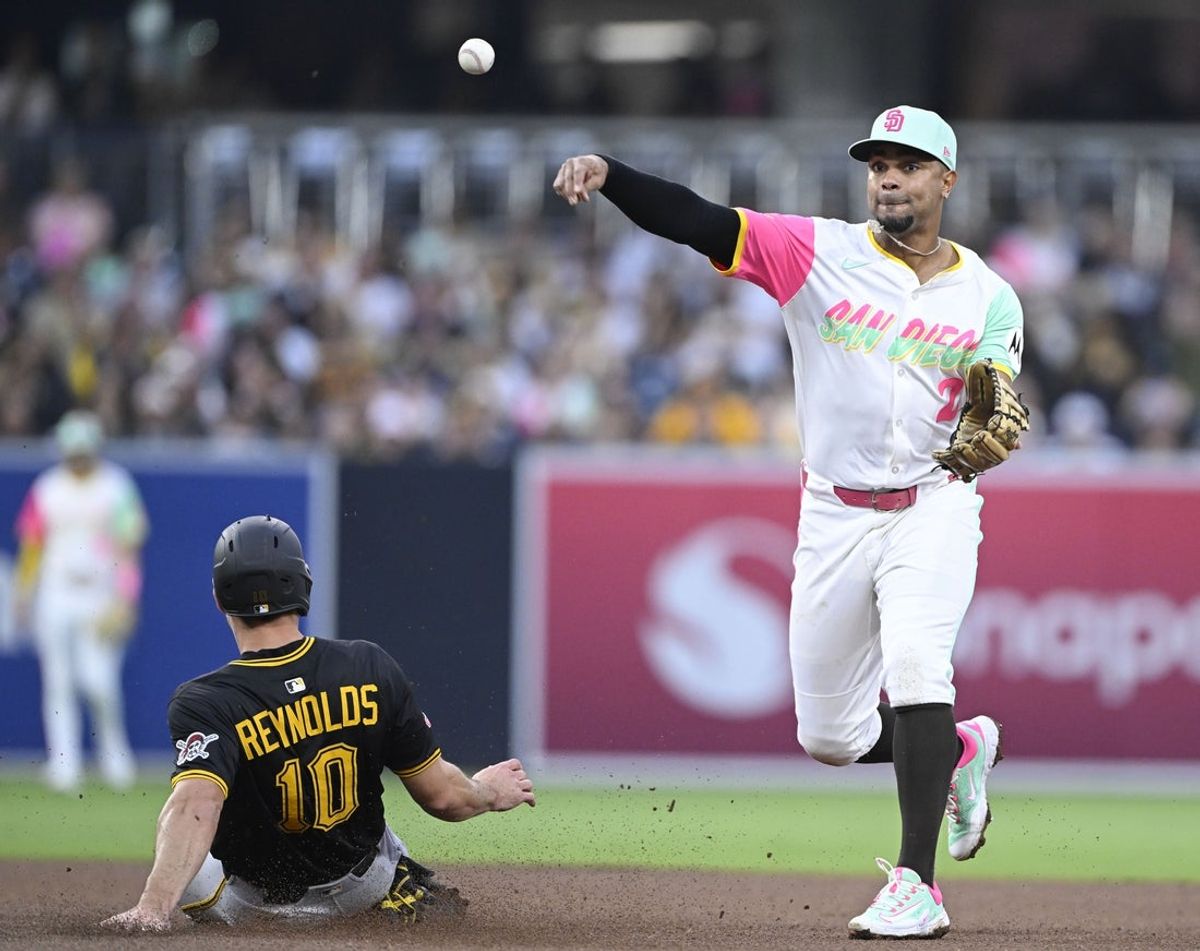 May 30, 2025; San Diego, California, USA; San Diego Padres shortstop Xander Bogaerts (2) throws over Pittsburgh Pirates right fielder Bryan Reynolds (10) during the fourth inning at Petco Park. Mandatory Credit: Denis Poroy-Imagn Images
