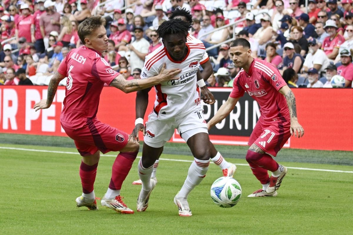 May 31, 2025; St. Louis, Missouri, USA; San Jose Earthquakes forward Ousseni Bouda (11) splits between St. Louis City midfielder Conrad Wallem (6) and St. Louis City defender Joey Zalinsky (71) at Energizer Park. Mandatory Credit: Scott Rovak-Imagn Images