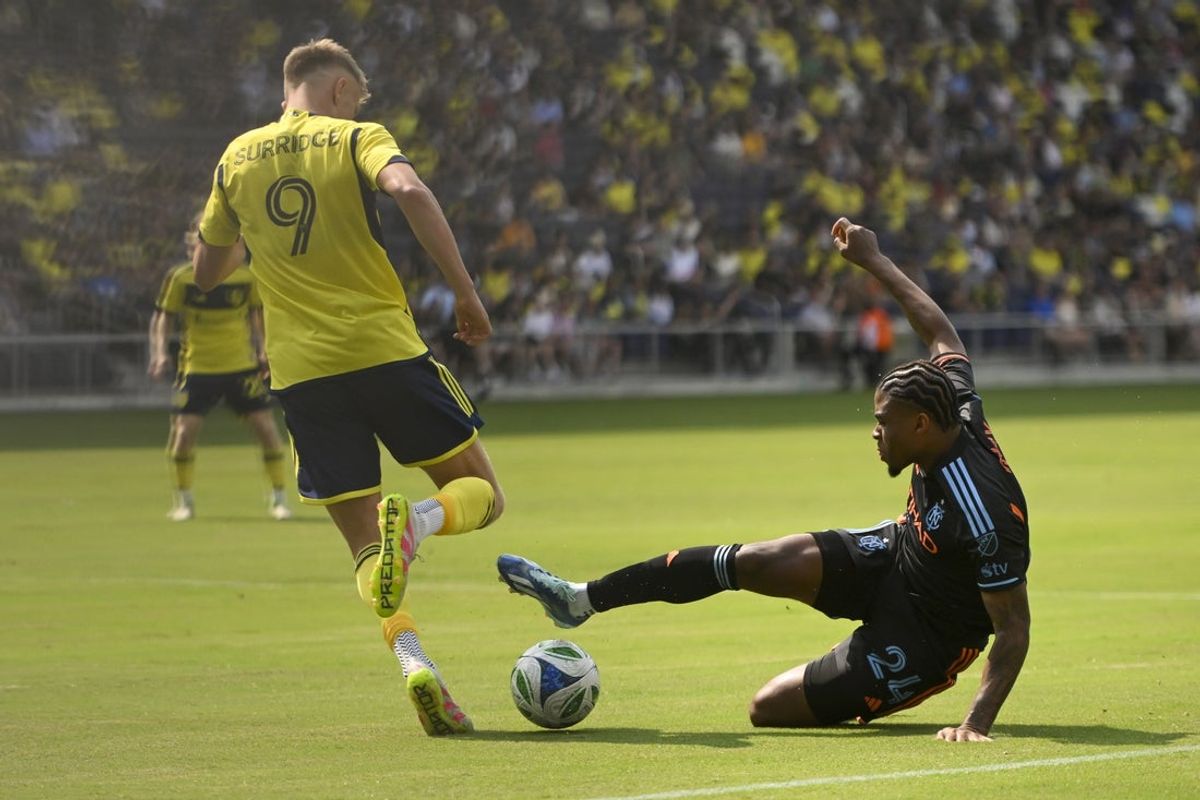 May 31, 2025; Nashville, Tennessee, USA;  New York City FC defender Tayvon Gray (24) tackles Nashville SC forward Sam Surridge (9) during the first half at Geodis Park. Mandatory Credit: Steve Roberts-Imagn Images