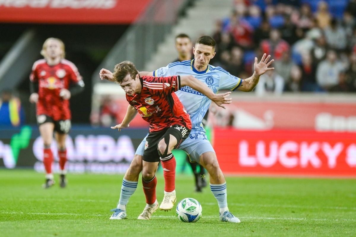 May 31, 2025; Harrison, New Jersey, USA; New York Red Bulls midfielder Daniel Edelman (75) shields the ball away from Atlanta United midfielder Bartosz Slisz (99) during the first half at Sports Illustrated Stadium. Mandatory Credit: John Jones-Imagn Images