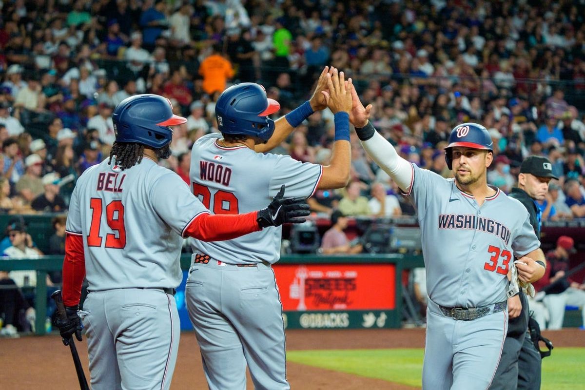 May 31, 2025; Phoenix, Arizona, USA;  Washington Nationals infielder Josh Bell (19) outfielder James Wood (29) and infielder Nathaniel Lowe (33) celebrate after Wood and Lowe score the second and third run of the first inning against the Arizona Diamondbacks at Chase Field. Mandatory Credit: Allan Henry-Imagn Images